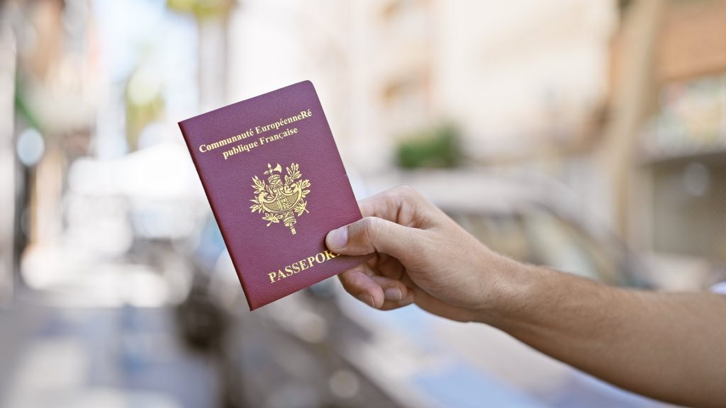 A hand holding a french passport