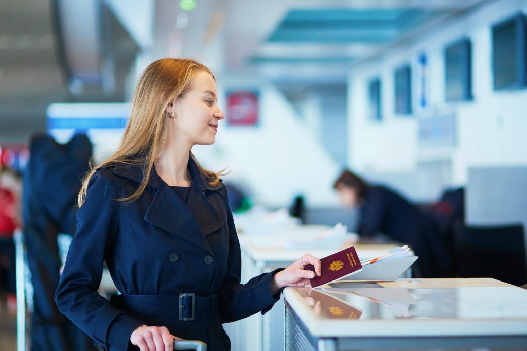 A person wearing a blue dress holding a france passport